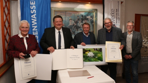 Fünf Personen mit goldenem Buch und Urkunden