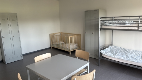 Raum mit Tisch, Doppelstockbetten und Kinderbett