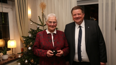 Ältere Damen und Mann vor Weihnachtsbaum