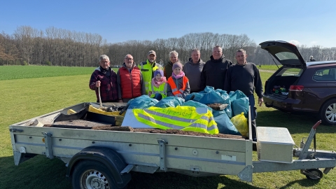 Gruppe hinter Anhänger mit Müll