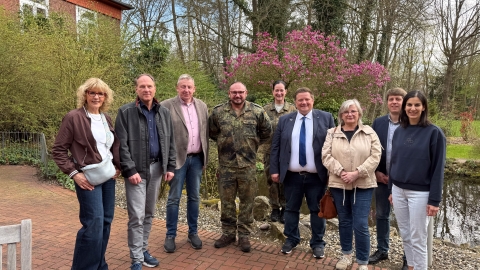 Frauen und Männer vor einem blühenden Baum 