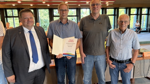 Menschen vor Publikum im Ratssaal 