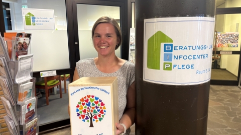 Frau neben Säule mit Box in der Hand