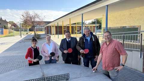 Menschen um eine Tischtennisplatte