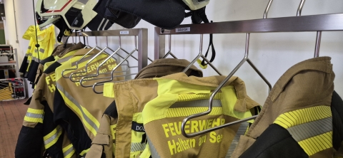Einsatzbekleidung der Feuerwehr auf einem Kleiderständer