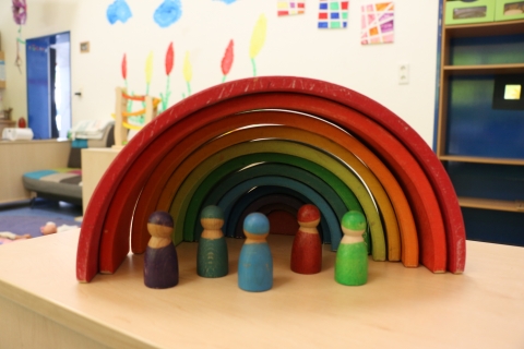 Holzpüppchen unter einem Regenbogen