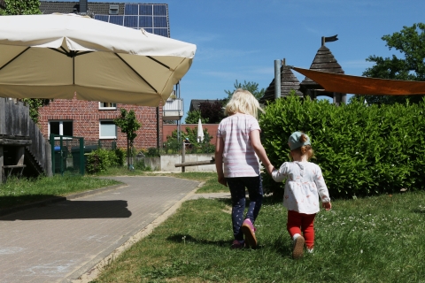 Zwei Kinder halten sich an den Händen