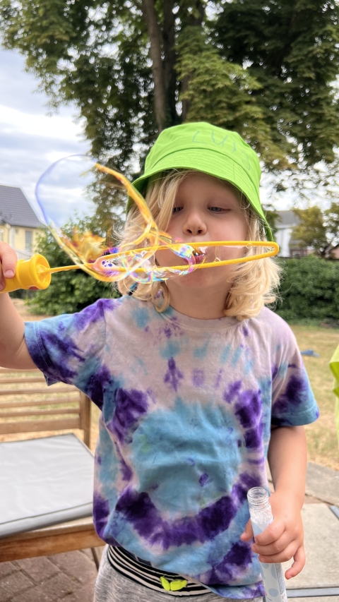 Foto eines Jungen der Seifenblasen pustet