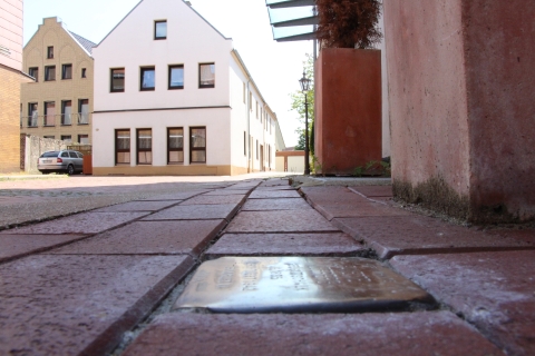 Goldener Stein im Boden vor Wohngebäude
