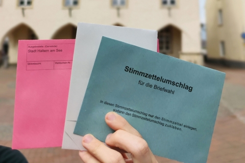 Briefumschläge aufgefächert, die in der Hand gehalten werden. 