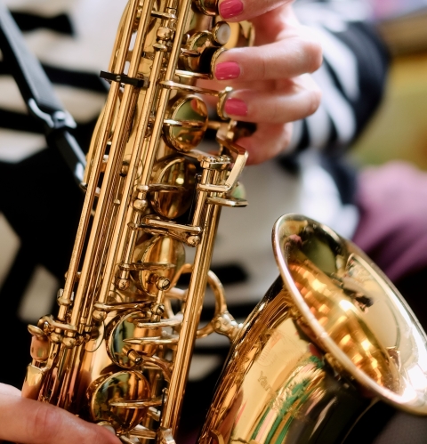 Bild zeigt Hände, die ein Saxophon spielen