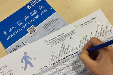 Fragebogen und Hand mit Stift beim Ausfüllen