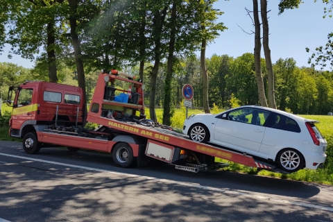 Weißes Auto auf Abschleppfahrzeug