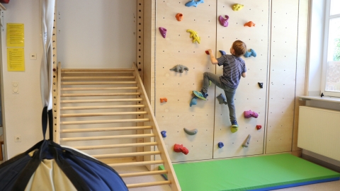 Turnhalle mit Kind an Kletterwand