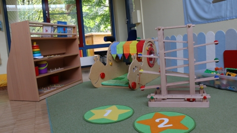 Spielgeräte aus Holz und ein Teppich mit Zahlen