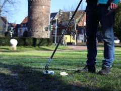 Person, die mit einem Greifer Müll aufhebt