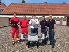 Vertreter von Feuerwehr und DLRG auf dem Dach der Feuerwache mit Drohne und Bürgermeister.