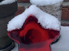 Bild zeigt einen roten Stern im Schnee