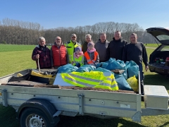 Gruppe hinter Anhänger mit Müll