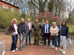 Frauen und Männer vor einem blühenden Baum 