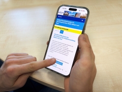 Handy mit Startseite des Serviceportals und Hand