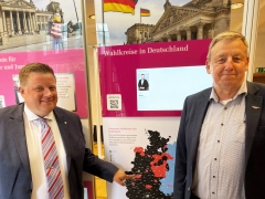 Zwei Männer vor Schautafel mit Wahlbezirken