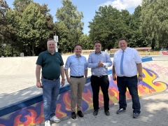 vier Männer auf Skatebahn mit Graffiti