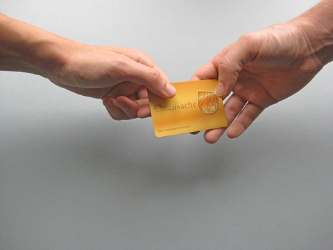 Hände, die nach der goldenen Ehrenamtskarte greifen