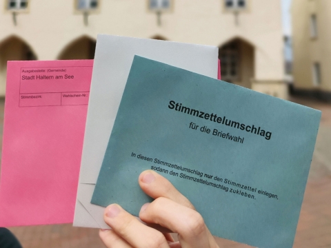 Briefumschläge aufgefächert, die in der Hand gehalten werden. 