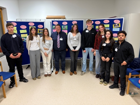 Acht junge Menschen mit Bürgermeister vor Stellwand 