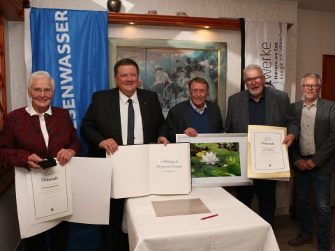 Fünf Personen mit goldenem Buch und Urkunden