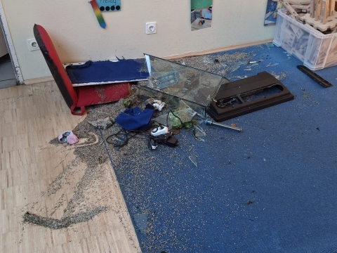 Aquarium in Scherben auf dem Boden verteilt