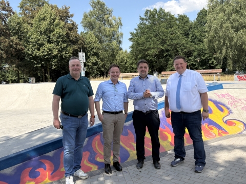 vier Männer auf Skatebahn mit Graffiti