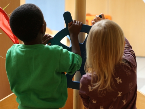 Kinderhände, die an einem Steuerrad drehen