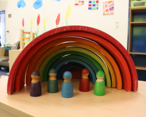 Holzpüppchen unter einem Regenbogen