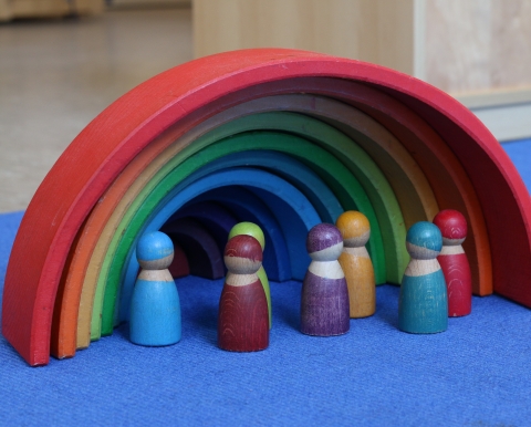 Bunte Holzpüppchen unter Holzregenbogen