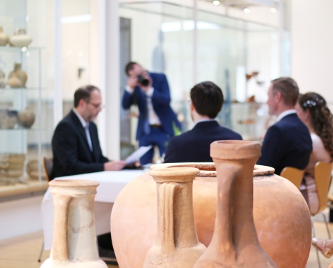 Paar im Römermuseum umgeben von Vasen und Tonkrügen