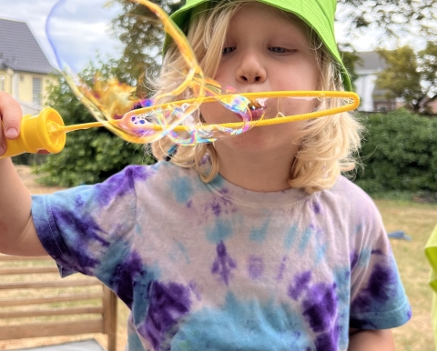 Foto eines Jungen der Seifenblasen pustet
