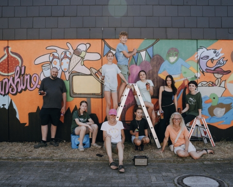 Gruppe von Menschen vor Graffiti